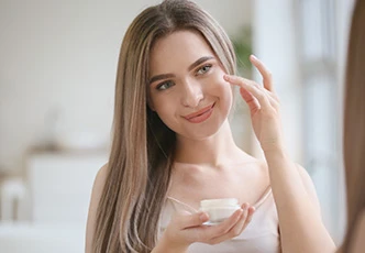 Mujer aplicándose crema en la cara